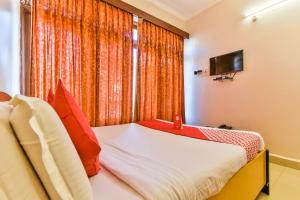 een slaapkamer met een bed en een raam met een televisie bij Hotel Pillar'S Near Immaculate Conception Church in Oud Goa