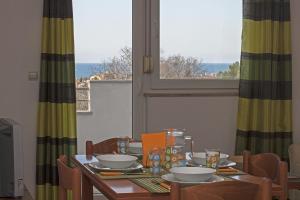 a dining room table with a view of the ocean at Apartments Kennedy in Peroj