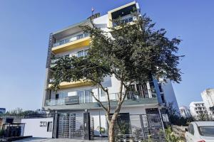 a white building with a tree in front of it at Townhouse Tipsyy Near Bestech Central Square Mall in Gurgaon