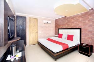 a bedroom with a bed and a tv in a room at Super OYO Hotel Continental Inn 42 in Chandīgarh