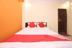 een slaapkamer met een groot bed met rode kussens bij OYO Hotel Vn Residency in Jabalpur