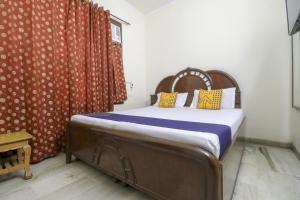 a bedroom with a bed with a red curtain at SPOT ON Motel Haryana in Chandīgarh