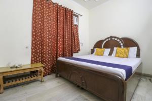 a bedroom with a bed and a table at SPOT ON Motel Haryana in Chandīgarh
