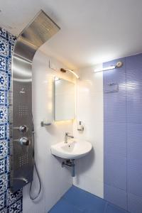 a bathroom with a sink and a mirror and a shower at Paradise Inn in Cochin