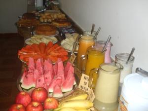 a table topped with plates of fruit and juice at Hotel Litoral in Aracaju