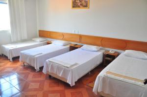 a hotel room with three beds in a room at Hotel Litoral in Aracaju