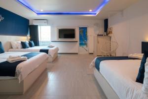 a hotel room with two beds and a tv at Akira Pattaya in Jomtien Beach
