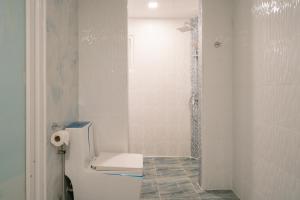 a white bathroom with a toilet and a shower at Akira Pattaya in Jomtien Beach +33 photos
