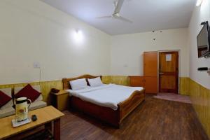ShamshiにあるOYO Hotel Sunbeamのベッドルーム(ベッド1台、ソファ付)