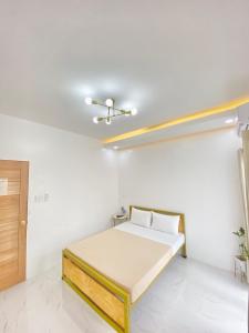 a white room with a bed and a ceiling at The Mansion - Olongapo in Olongapo