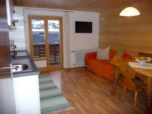 Cette chambre comprend une cuisine, une table et un lit. dans l'établissement Ferienwohnung Natter in Mellau, à Mellau