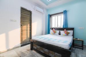a bedroom with a bed with blue walls and a window at OYO Home Dk Homes in Maula Ali