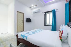 a white bedroom with a bed and a window at Hotel O Home Dk Homes in Hyderabad