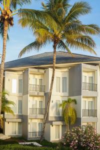 a building with palm trees in front of it at Swiss-Belinn Luwuk in Luwuk