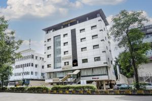 un grande edificio bianco con uno scivolo di fronte di Super Townhouse OAK Regal Inn Near Sant Tukaram Nagar Metro Station a Chinchwad