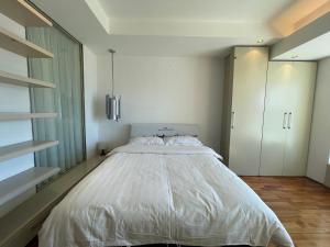 a bedroom with a large white bed and cabinets at Beijing Elegant Seasons Park Apartment in Beijing
