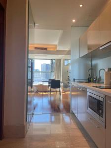 uma cozinha com electrodomésticos de aço inoxidável e uma sala de jantar em Beijing Elegant Seasons Park Apartment em Pequim