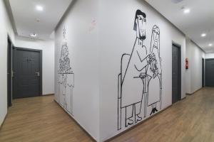 a hallway with a drawing on the wall at Townhouse Spruce Hotels Bellandur in Bangalore