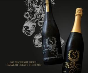 Sarabah Estate Vineyard & Villa في Beechmont: زجاجتان من النبيذ تقعان بجوار بعضهما