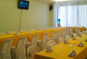 einen Konferenzraum mit gelben Tischen und weißen Stühlen in der Unterkunft Jade Dragons Suites Davao in Davao City