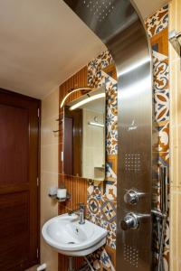 La salle de bains est pourvue d'un lavabo et d'un miroir. dans l'établissement Paradise Inn, à Cochin