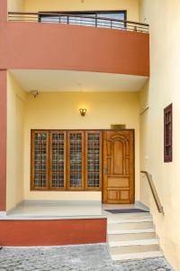 een huis met een houten deur en trap bij Paradise Inn in Cochin