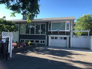 a large house with a garage and a driveway at Cheerful home close to downtown Kelowna in Kelowna