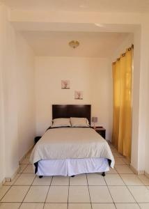um quarto com uma cama grande num quarto em Casa en el Centro de Ilobasco em Nanastepeque