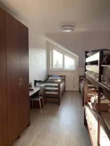 a room with bunk beds and a desk and a table at A&K Retreat Center in Prilbichi