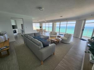 a living room with a couch and chairs and the ocean at Burleigh Surf Apartments in Gold Coast
