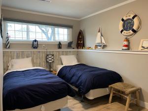 a bedroom with two beds and a clock on the wall at Cheerful home close to downtown Kelowna in Kelowna