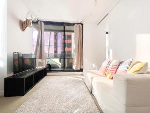 un soggiorno con divano bianco e TV di MY80 Apartment located in the inner of Melbourne CBD a Melbourne