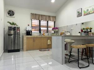 uma cozinha com um frigorífico de aço inoxidável e armários de madeira em Family 15 Pax Corner Lot House / Free WiFi em Subang Jaya