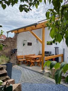 a wooden pergola with a wooden table and benches at Casa Eifel in Beilingen