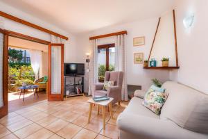 a living room with a couch and a tv at Casa Can Pinyol in Cala Figuera