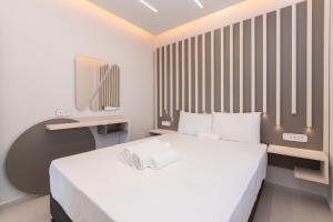 a bedroom with a white bed and a desk at SithoniaRS Melora Luxury Apartment in Nikiti