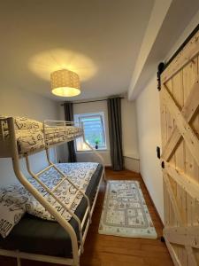 a bedroom with a bunk bed and a wooden door at Casa Eifel in Beilingen