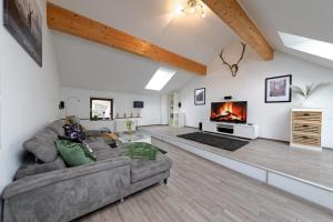 a living room with a couch and a fireplace at Casa Eifel in Beilingen