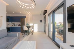 a living room and kitchen with a couch and a table at SithoniaRS Melora Luxury Apartment in Nikiti