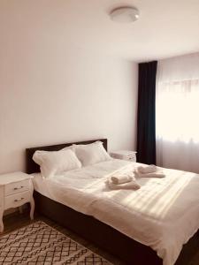 - une chambre avec un grand lit blanc et une fenêtre dans l'établissement NARCISA, à Piatra Neamţ
