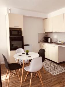 - une cuisine avec une table et des chaises dans la chambre dans l'établissement NARCISA, à Piatra Neamţ