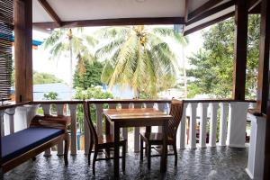 a porch with a table and chairs and a palm tree at Rainbow Bay Beach & Dive Resort in Siquijor