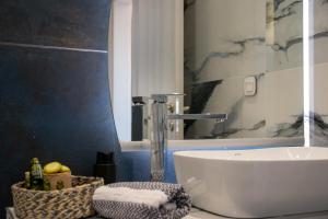 a bathroom with a white sink and a mirror at SithoniaRS Melora Luxury Apartment in Nikiti