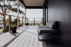 圣海伦斯Bayview Lodge - Views Views Views!的木甲板上设有沙发的门廊