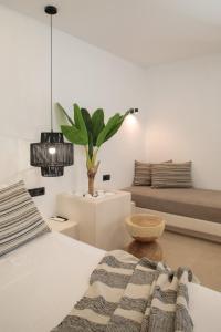 Naxos Village hotel في ناكسوس تشورا: غرفة نوم مع سرير وزرع الفخار