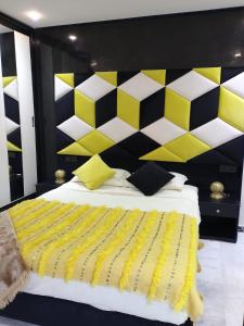 a bedroom with a large bed with a yellow and white headboard at Serenehouse in Marrakesh