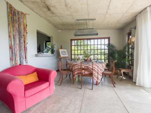 a living room with a pink couch and a table at Green Cottage Chamarel in Chamarel