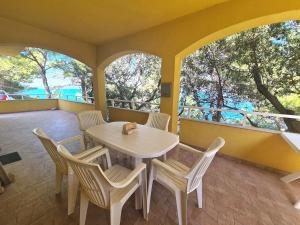 a white table and chairs on a balcony with a table and chairsktop at Vila Elena in Prigradica