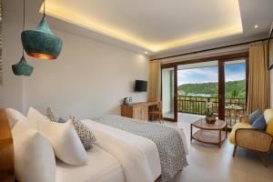 a bedroom with a large bed and a balcony at The Acala Shri Sedana in Nusa Lembongan