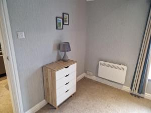 a bedroom with a dresser with a lamp on it at Gorgeous 1 Bed Apartment in Wetwang in Great Driffield